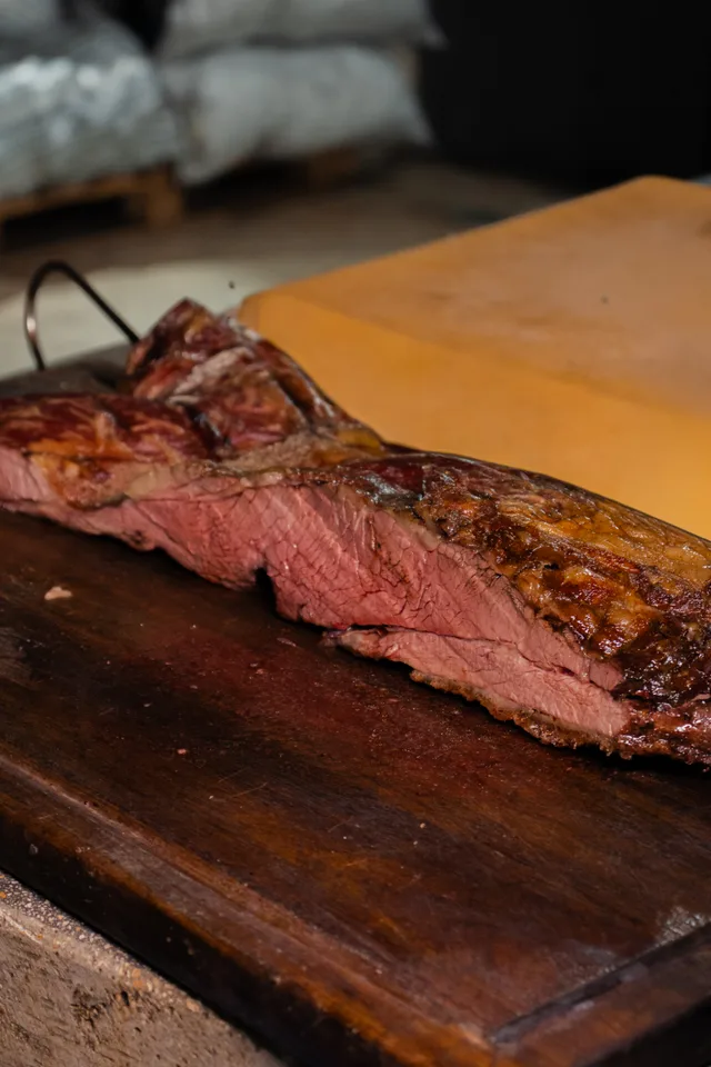 Carne a la parrilla cortada sobre una tabla en Criollo Restó