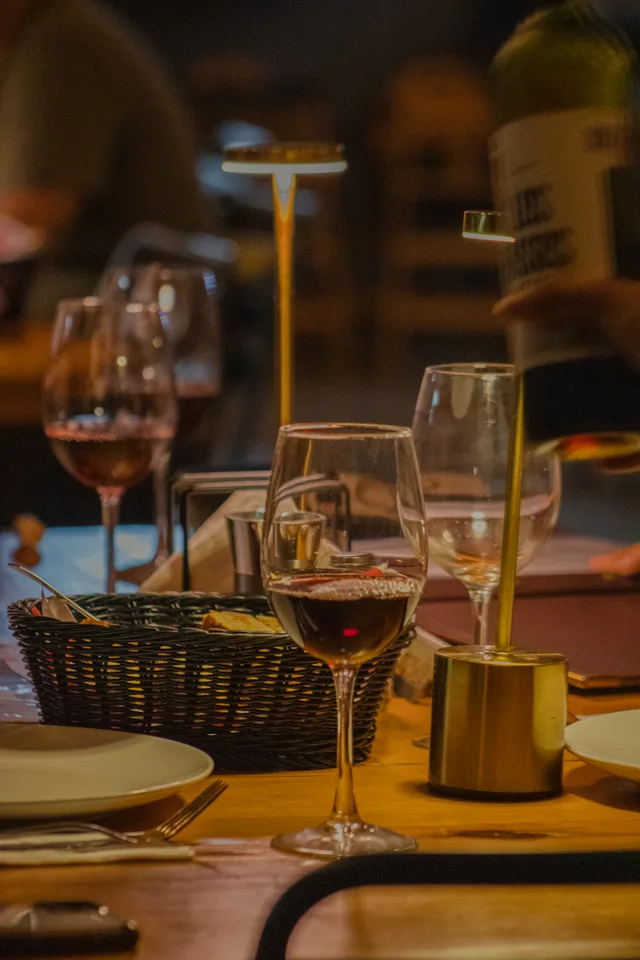 Copas de vino y una mesa preparada para compartir en Criollo